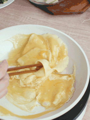 油6成熱時，下雞蛋液，邊緣凝固時翻拌成塊狀。